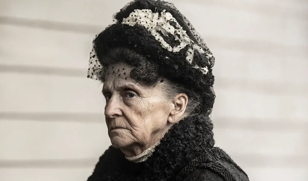 Πορτρέτο της Hetty Green με μαύρο καπέλο και αυστηρή έκφραση, AI-generated.