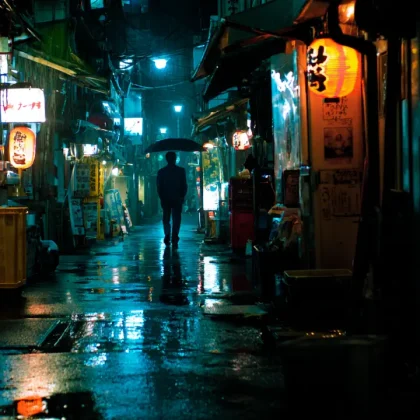 Σκοτεινό στενό στο Τόκιο με μοναχικό άνθρωπο τη νύχτα.